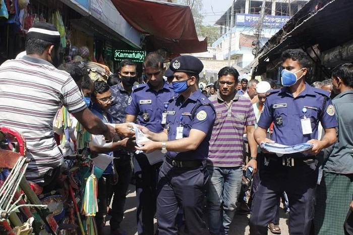 জনসাধারনের নিকট লিফলেট দিচ্ছেন পুলিশ